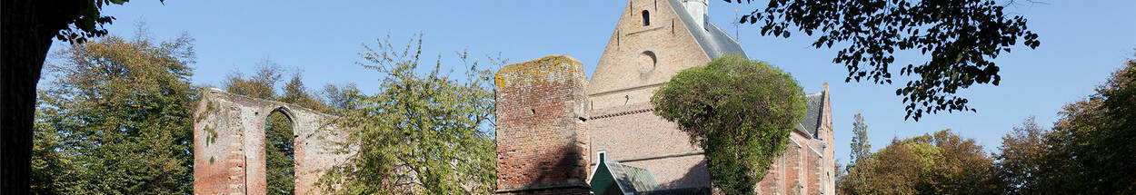 Foto van de Ruinekerk, Bergen, met een kerk en een ruine ervoor
