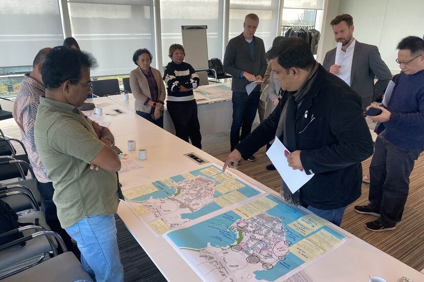 People standing around a table with maps spread out on it