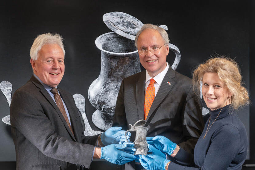 Ambassador Karel van Oosterom and Susan Lammers, director RCE, received a pewter jug from the Rooswijk shipwreck handed over by Duncan Wilson, CEO Historic England.